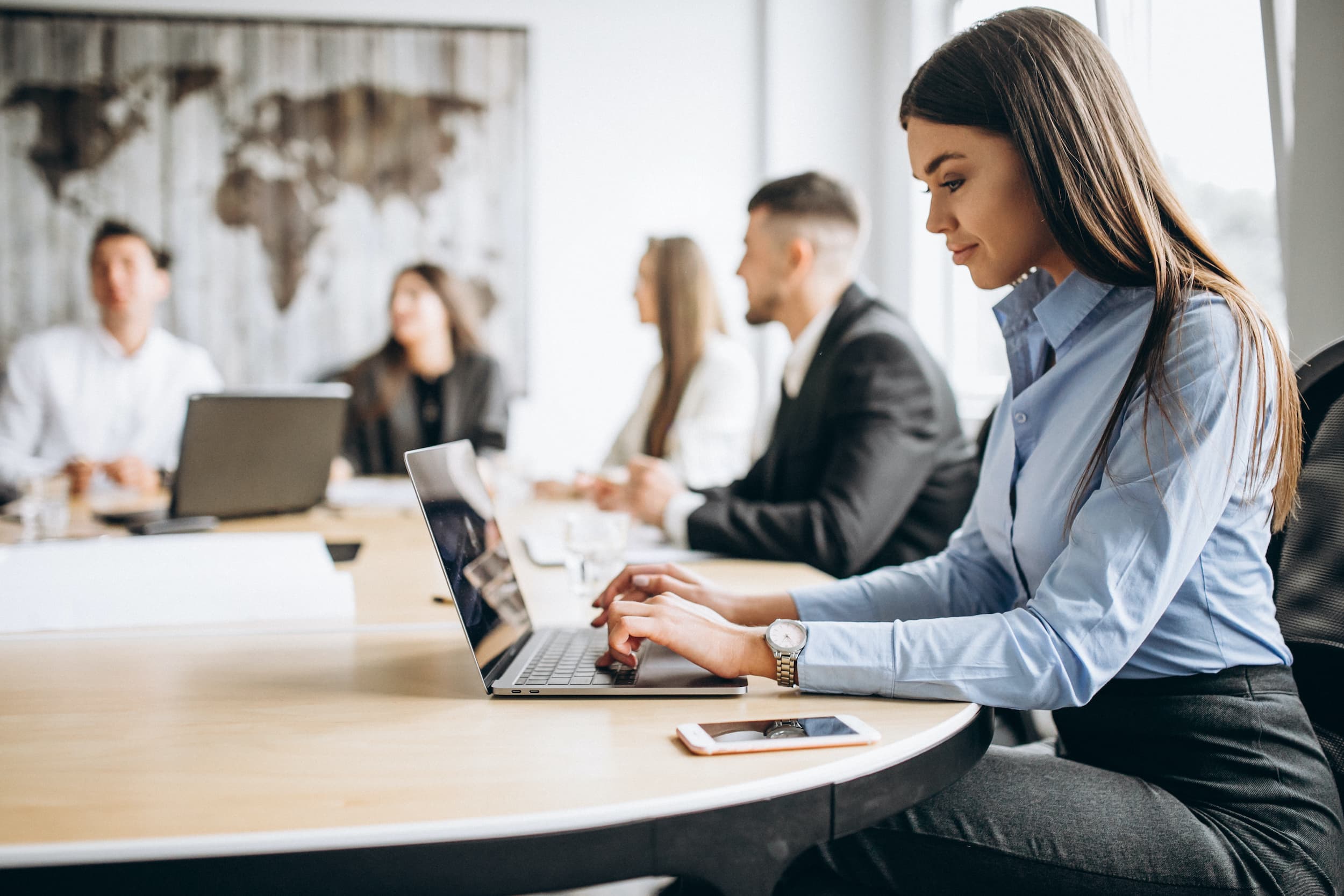 Female employee in office using laptop at table